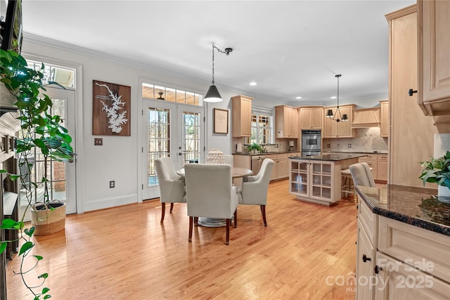 dining room with crown molding, sink, light hardwood / wood-style floors, and french doors