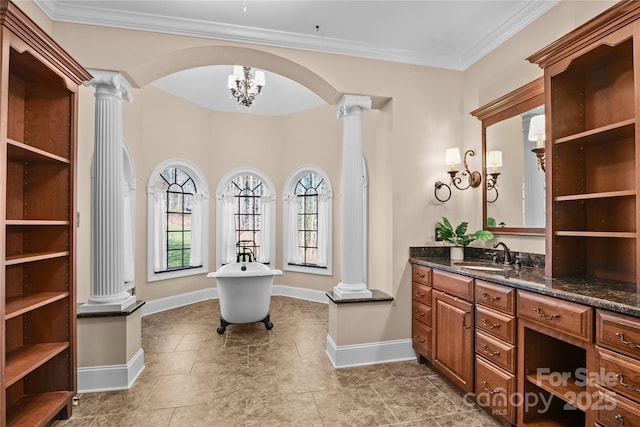 bathroom featuring vanity, a bathtub, decorative columns, and crown molding