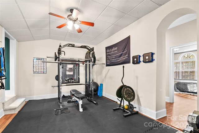 workout area with lofted ceiling, a paneled ceiling, and ceiling fan