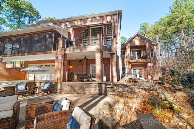 back of house with outdoor lounge area, a patio area, and a sunroom