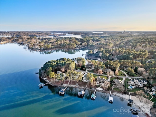 aerial view at dusk featuring a water view