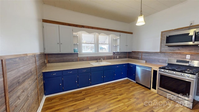 kitchen featuring decorative light fixtures, open shelves, white cabinetry, appliances with stainless steel finishes, and light countertops