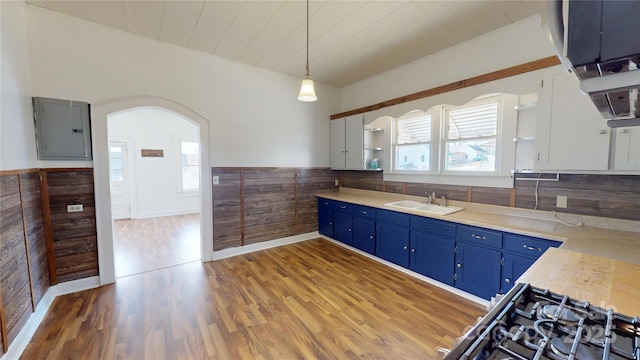 kitchen with white cabinetry, open shelves, hanging light fixtures, and a sink