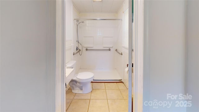 bathroom featuring tile patterned flooring, toilet, and a shower