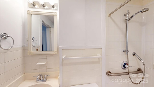 full bathroom featuring tile walls, a shower, and a sink