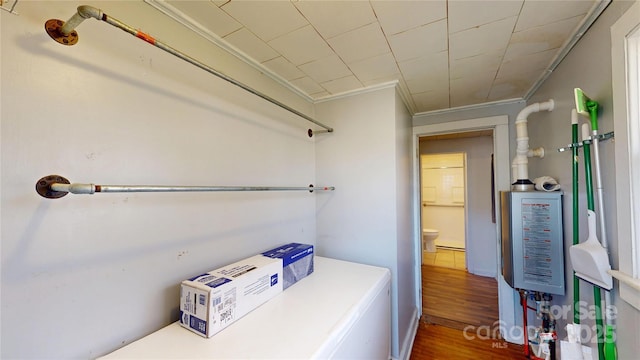 clothes washing area with crown molding, dark wood-type flooring, laundry area, and washer and dryer