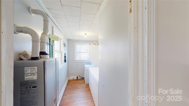 hallway with washer and clothes dryer and light wood-style floors