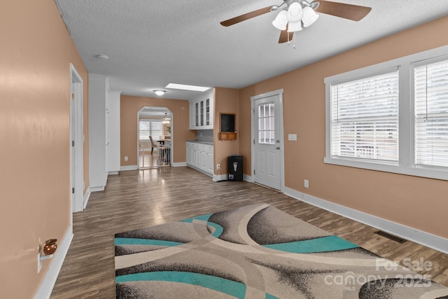 exercise room with ceiling fan, dark hardwood / wood-style floors, and a textured ceiling