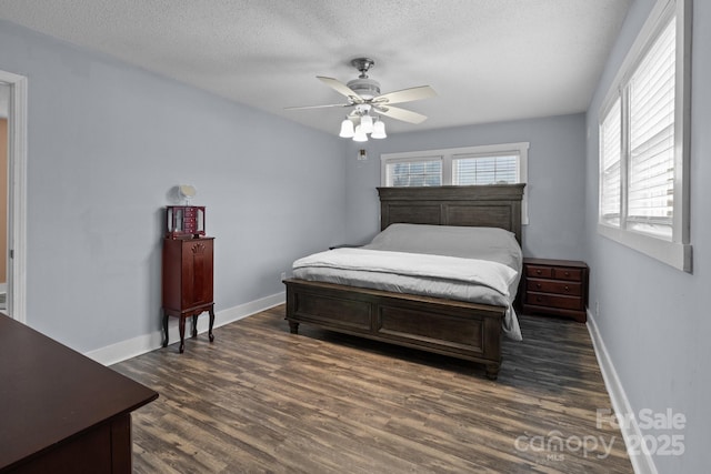 bedroom with ceiling fan, dark hardwood / wood-style floors, and a textured ceiling