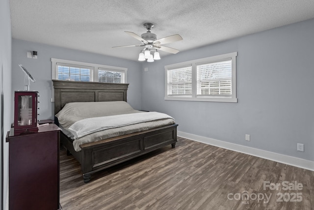 bedroom featuring dark wood-type flooring, ceiling fan, and a textured ceiling