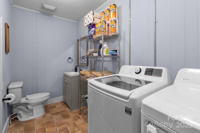 laundry room with washer and dryer and a textured ceiling