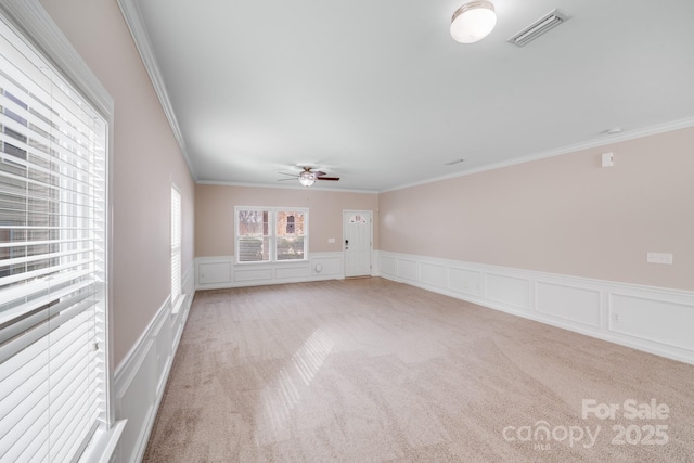 carpeted spare room with crown molding and ceiling fan