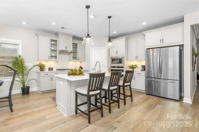 kitchen with pendant lighting, appliances with stainless steel finishes, and white cabinets