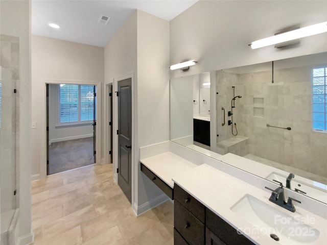 bathroom featuring tile patterned floors, a tile shower, and vanity