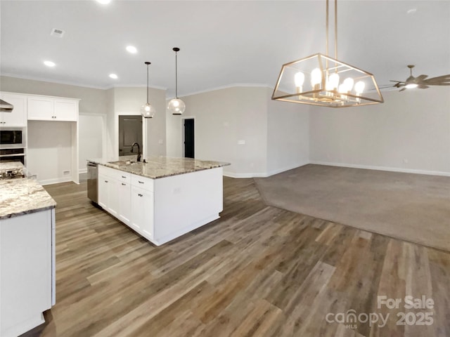 kitchen with hanging light fixtures, dishwasher, sink, white cabinetry, and a kitchen island with sink