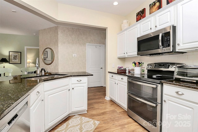 9119 Gander Dr, Charlotte, NC 28277 - kitchen with stainless steel appliances, sink, white cabinets, and light hardwood / wood-style floors