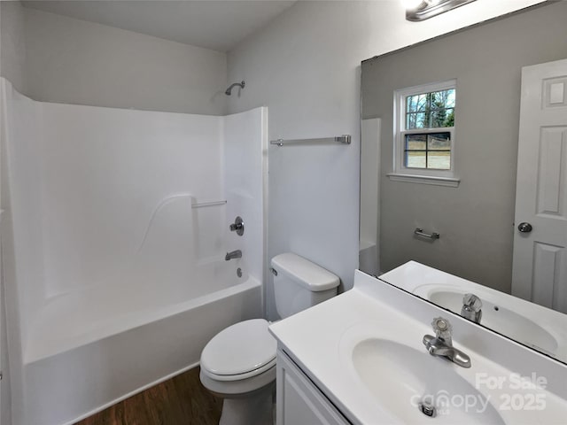 full bathroom featuring hardwood / wood-style flooring,  shower combination, vanity, and toilet