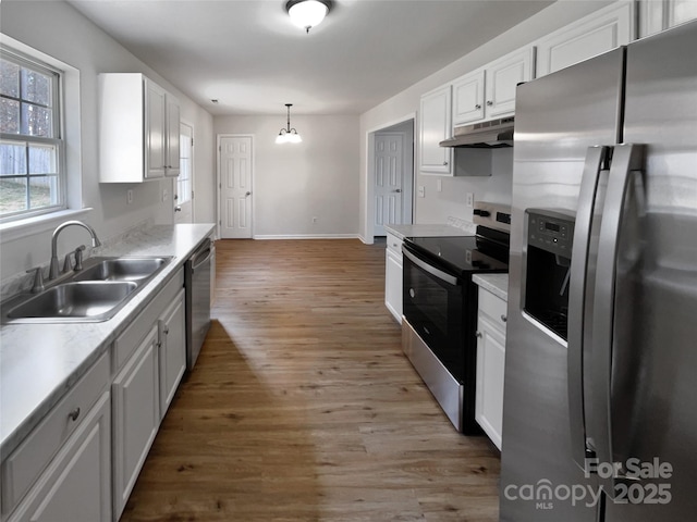 kitchen with hanging light fixtures, white cabinetry, appliances with stainless steel finishes, and sink