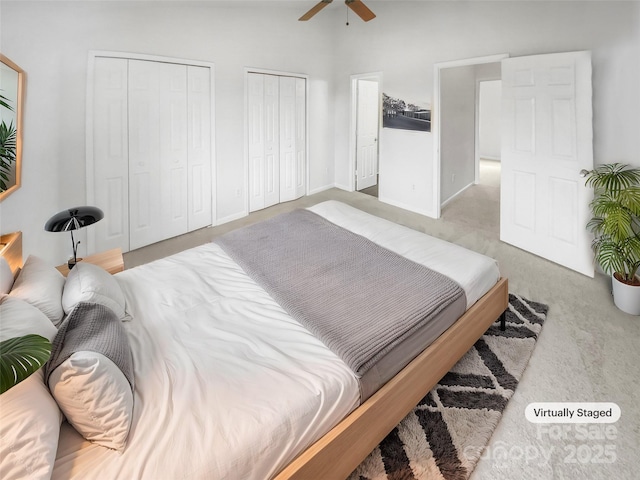 carpeted bedroom featuring multiple closets and ceiling fan