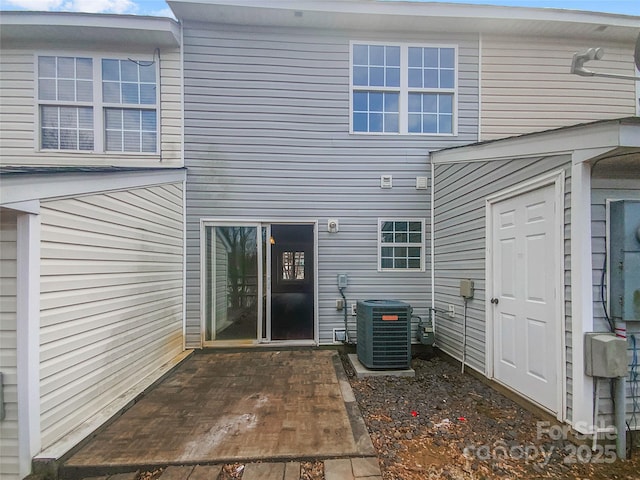 rear view of house featuring central AC unit and a patio