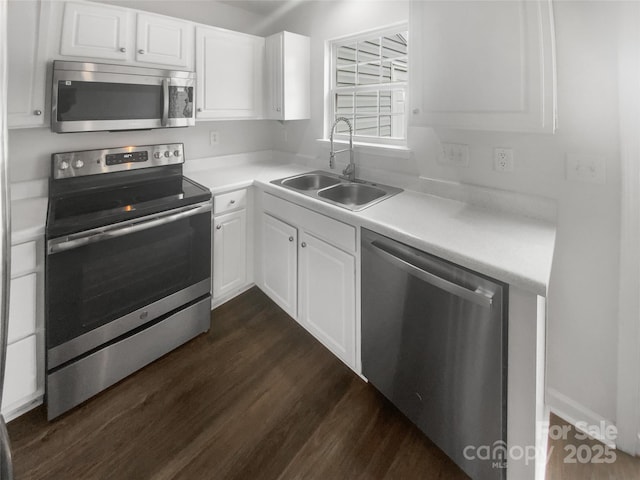 kitchen with stainless steel appliances, white cabinetry, sink, and dark hardwood / wood-style flooring