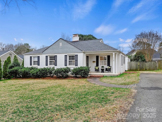 ranch-style home featuring a porch and a front yard