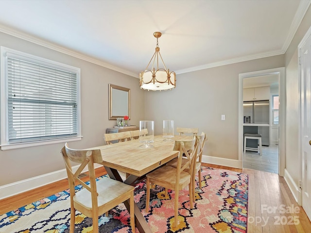 dining area with wood-type flooring, crown molding, a chandelier, and a healthy amount of sunlight