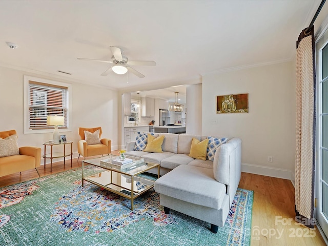 living room featuring crown molding, ceiling fan, and hardwood / wood-style floors