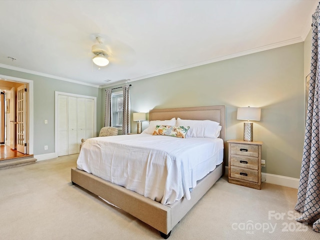 bedroom with ornamental molding, light colored carpet, ceiling fan, and a closet