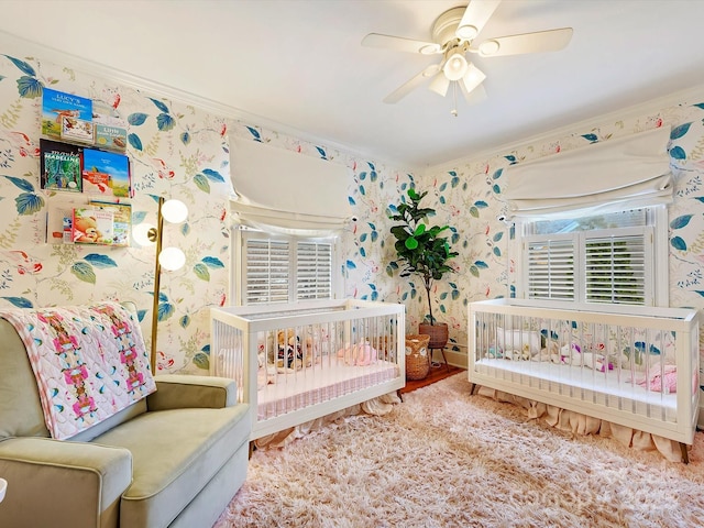 bedroom featuring crown molding, a nursery area, and ceiling fan