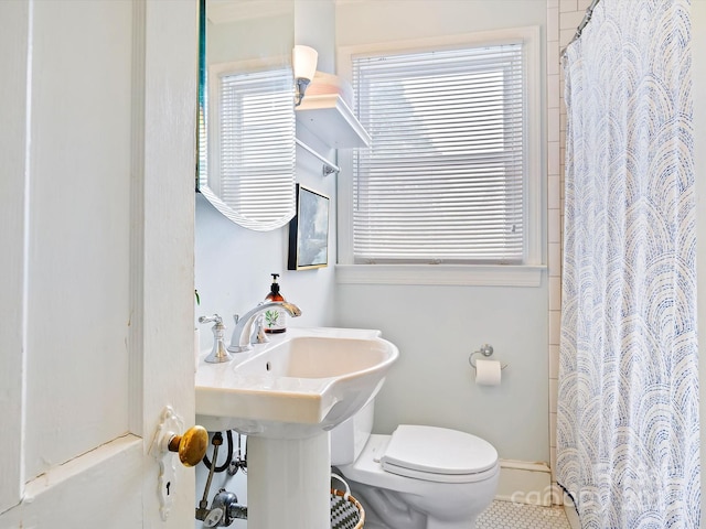 bathroom with a shower with curtain, tile patterned floors, and toilet