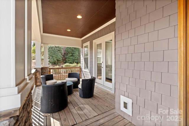 wooden deck with covered porch and french doors