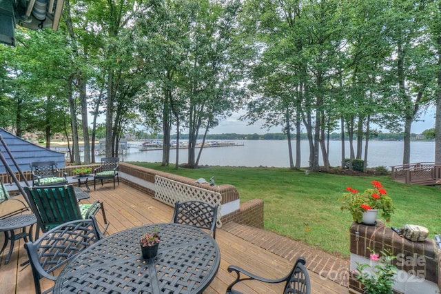 wooden deck with a yard and a water view