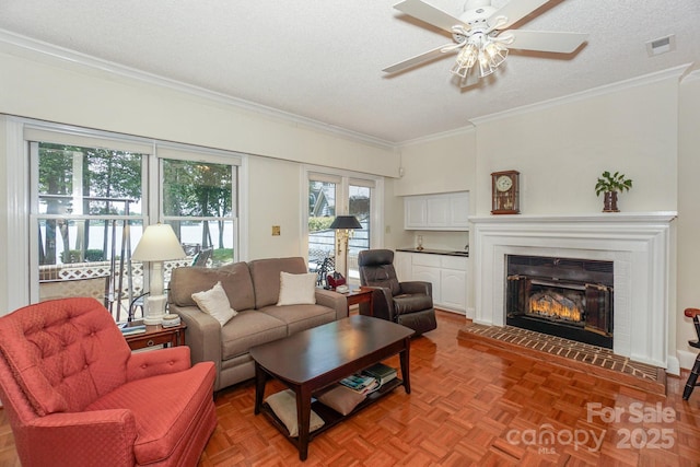 405 NW Dr, Davidson, NC 28036 - living room featuring ceiling fan, a fireplace, ornamental molding, a textured ceiling, and parquet flooring