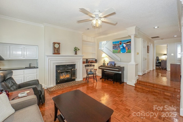 405 NW Dr, Davidson, NC 28036 - living room featuring a tile fireplace, decorative columns, parquet floors, a textured ceiling, and built in shelves