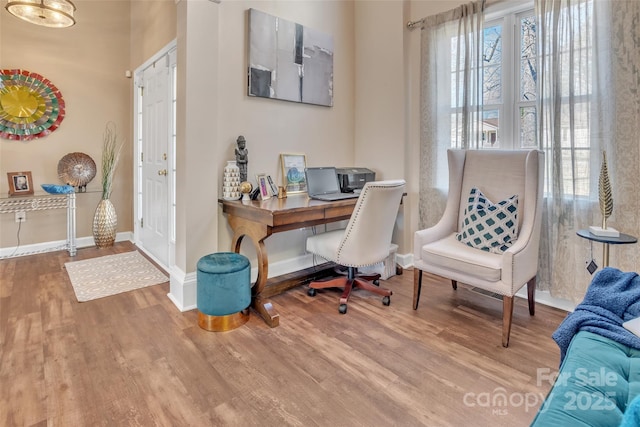 office with a healthy amount of sunlight, baseboards, and wood finished floors