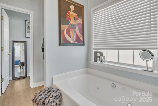 full bathroom featuring a whirlpool tub and wood finished floors