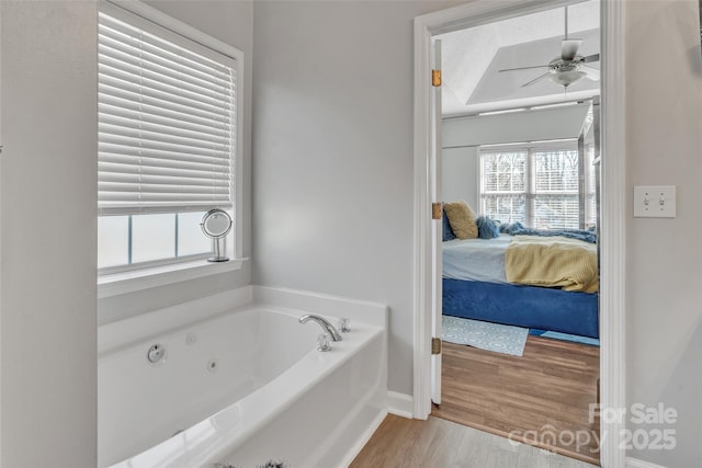 bathroom featuring a jetted tub, a ceiling fan, wood finished floors, and ensuite bathroom