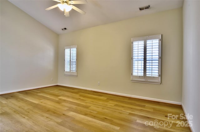 unfurnished room with wood finished floors, visible vents, and baseboards