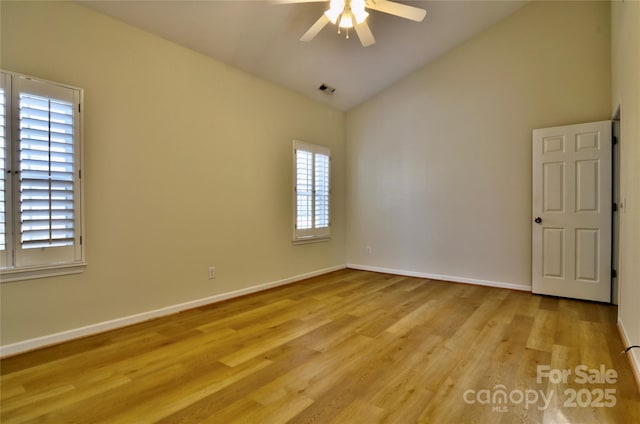 spare room featuring light wood finished floors, visible vents, ceiling fan, high vaulted ceiling, and baseboards