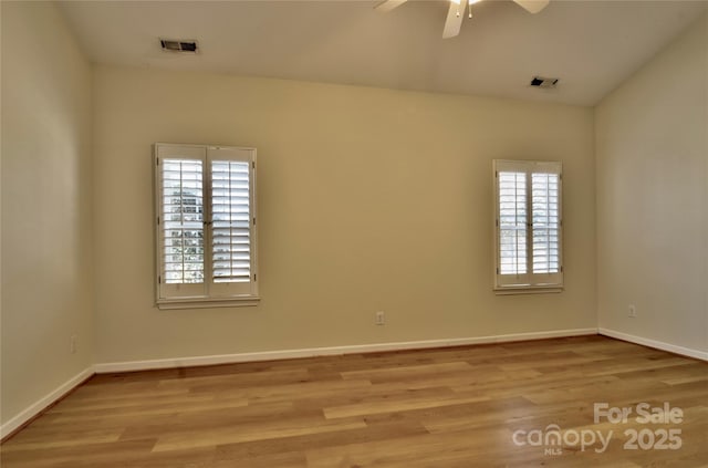 empty room featuring visible vents, baseboards, and wood finished floors