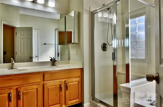 full bath with double vanity, a stall shower, and a sink