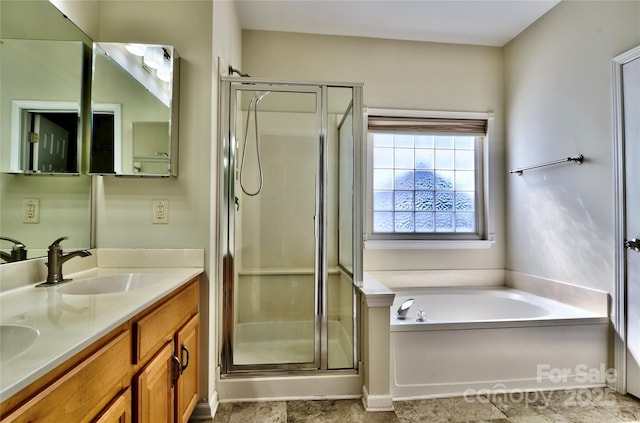 bathroom with a bath, a stall shower, double vanity, and a sink