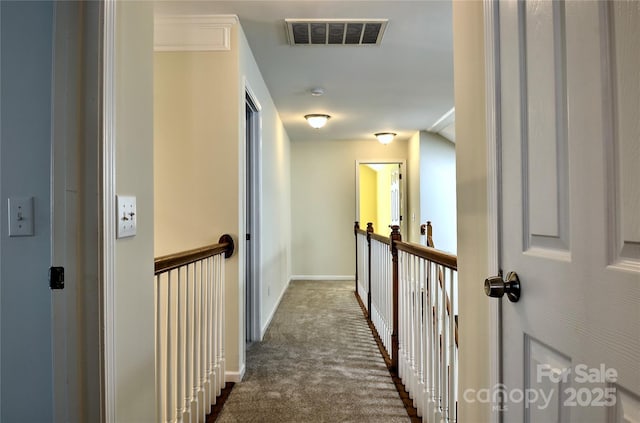 corridor featuring baseboards, visible vents, and dark carpet