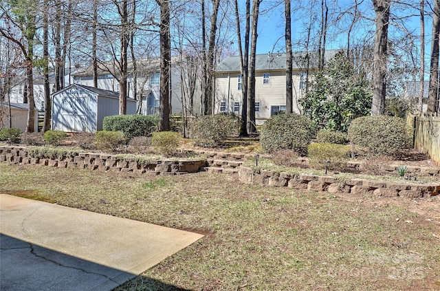 view of yard featuring a shed, an outdoor structure, and fence