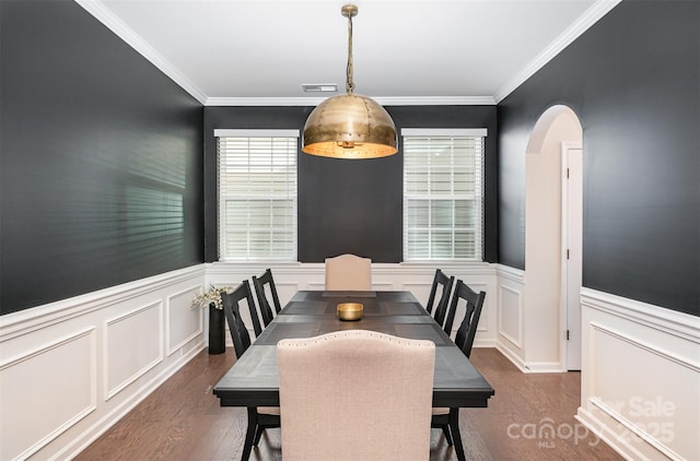 dining area featuring a wainscoted wall, visible vents, arched walkways, and dark wood-type flooring