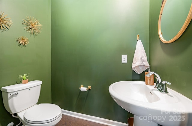 bathroom with a sink, toilet, and baseboards