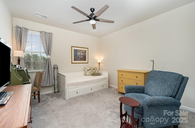 sitting room with baseboards, visible vents, a ceiling fan, and light colored carpet