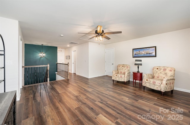 living area with visible vents, baseboards, dark wood finished floors, a ceiling fan, and an upstairs landing