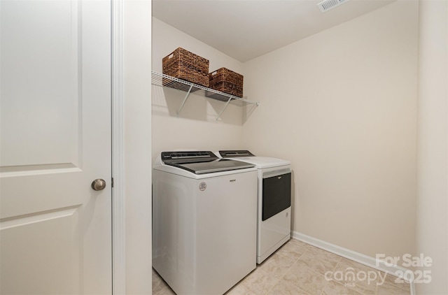 washroom featuring laundry area, light tile patterned floors, baseboards, visible vents, and washing machine and clothes dryer